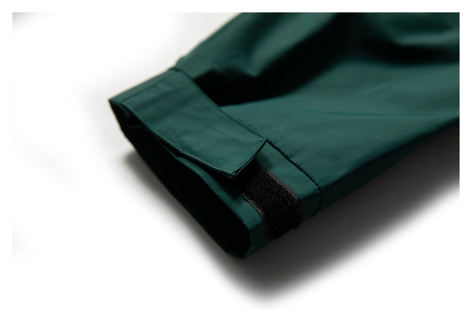 Close-up of a dark teal sleeve cuff with an adjustable hook-and-loop tab.