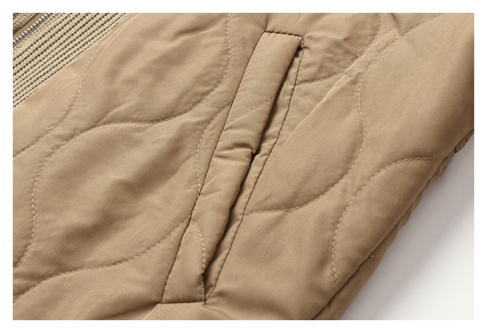 Close-up of a slanted pocket opening and curved quilting on a tan jacket.
