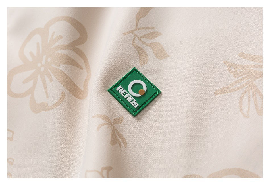 Close-up of a green diamond-shaped REPOS patch on cream fabric with a pale beige floral print.