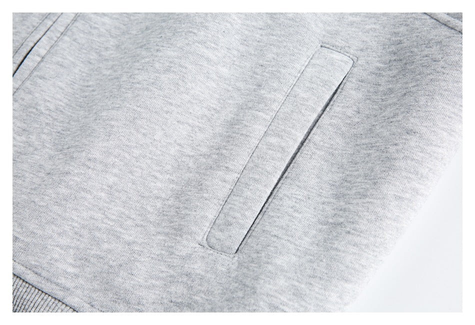 Close-up of a vertical welt pocket on a heather gray jacket.