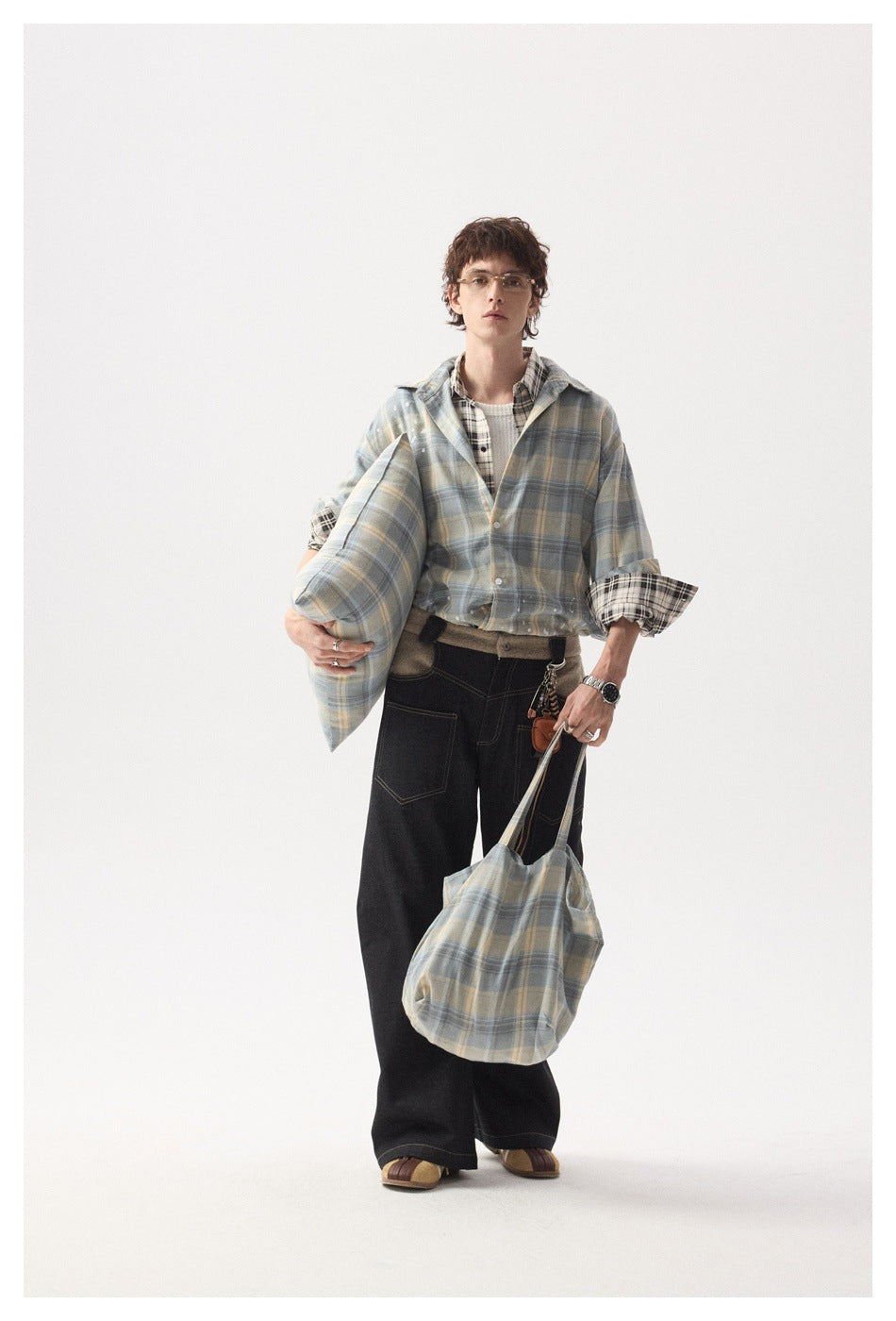 Full-length model wearing a blue-gray plaid overshirt with pale yellow checks and white splatter details.