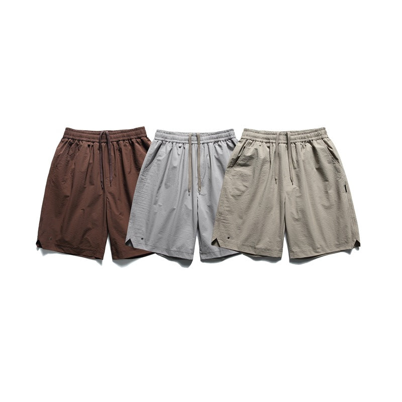 Three pairs of elastic-waist shorts shown together in brown, light gray, and beige.