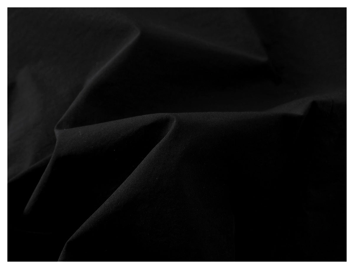 Close-up of black fabric showing its subtle texture and soft folds.