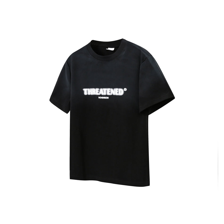 Black short-sleeve T-shirt with blurred white THREATENED chest print, flat front view