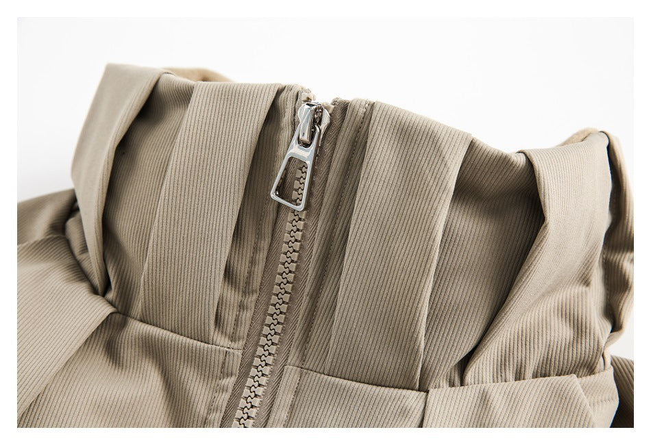 Close-up of a beige ribbed jacket's collar and chunky front zipper with a metal pull.