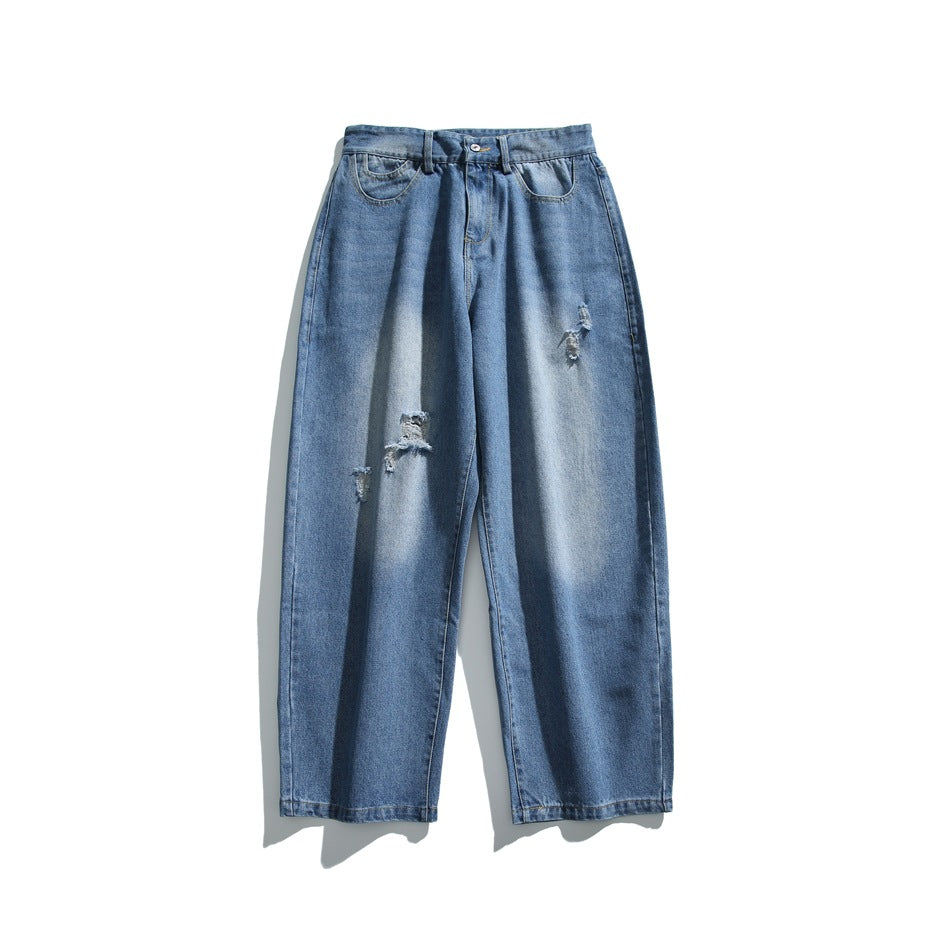 Flat lay of blue washed wide-leg jeans with faded patches and frayed distressed rips, front view