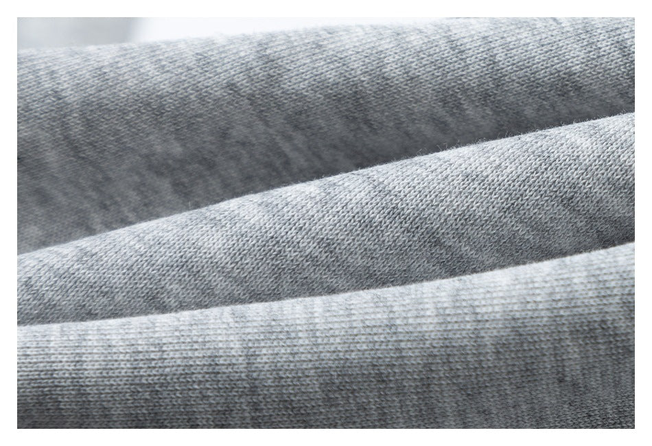 Close-up of light gray knit fabric showing its fine woven texture and overlapping folds.