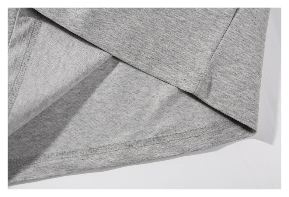 Close-up of the gray sweatshirt hem and stitching, with the fabric folded back.
