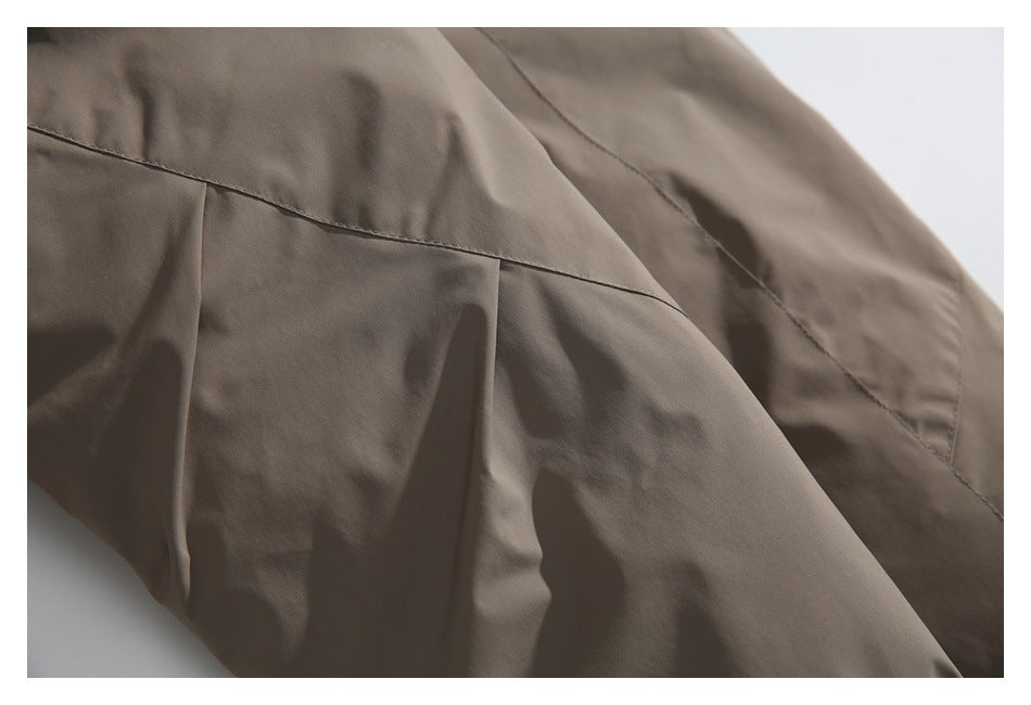 Close-up of taupe garment panels with stitched seams and a pleated section.