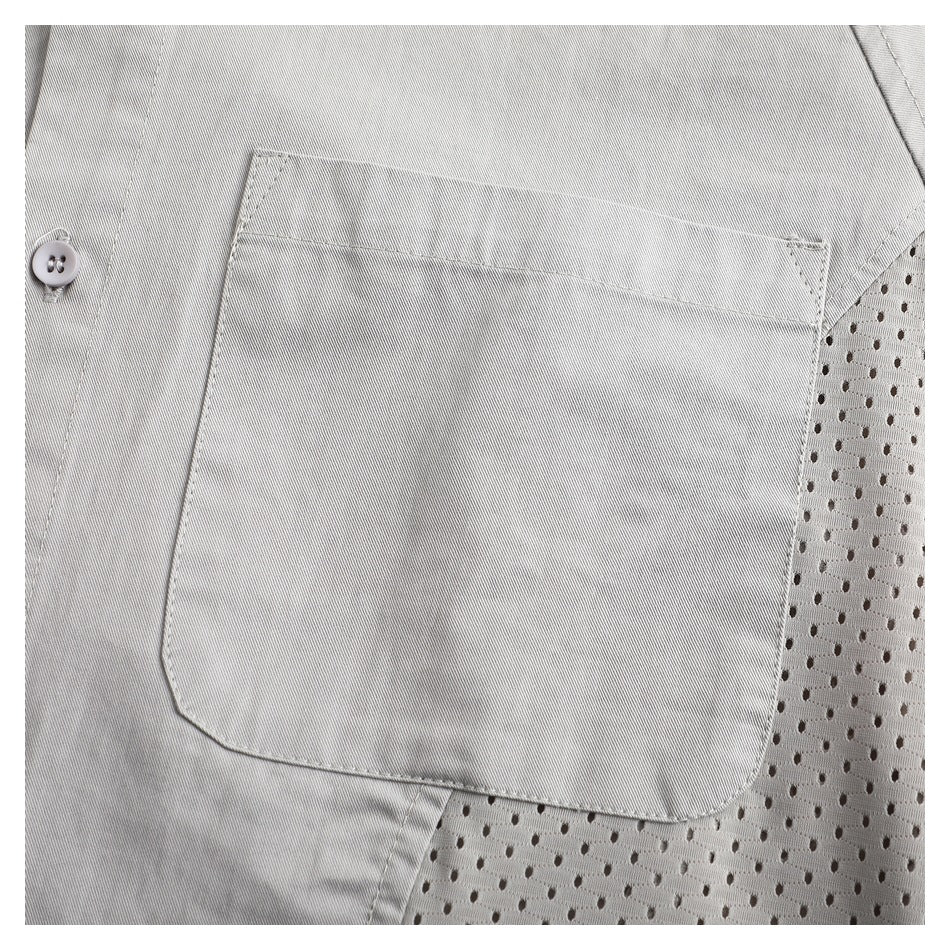 Close-up of a light gray shirt with a large patch pocket beside a perforated mesh panel.