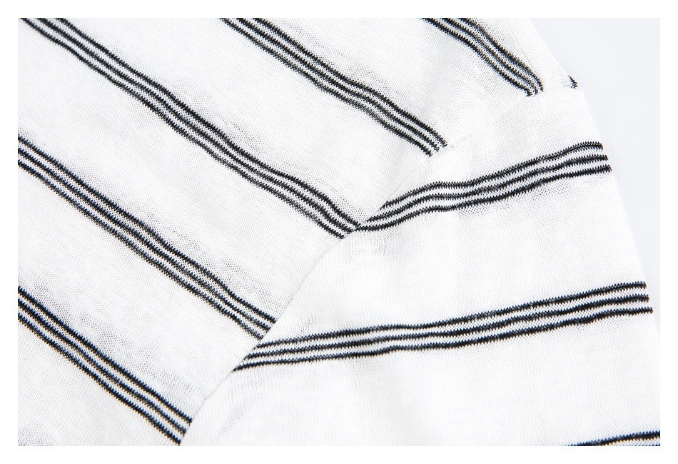 Close-up of white knit fabric with narrow black stripes meeting at a seam.