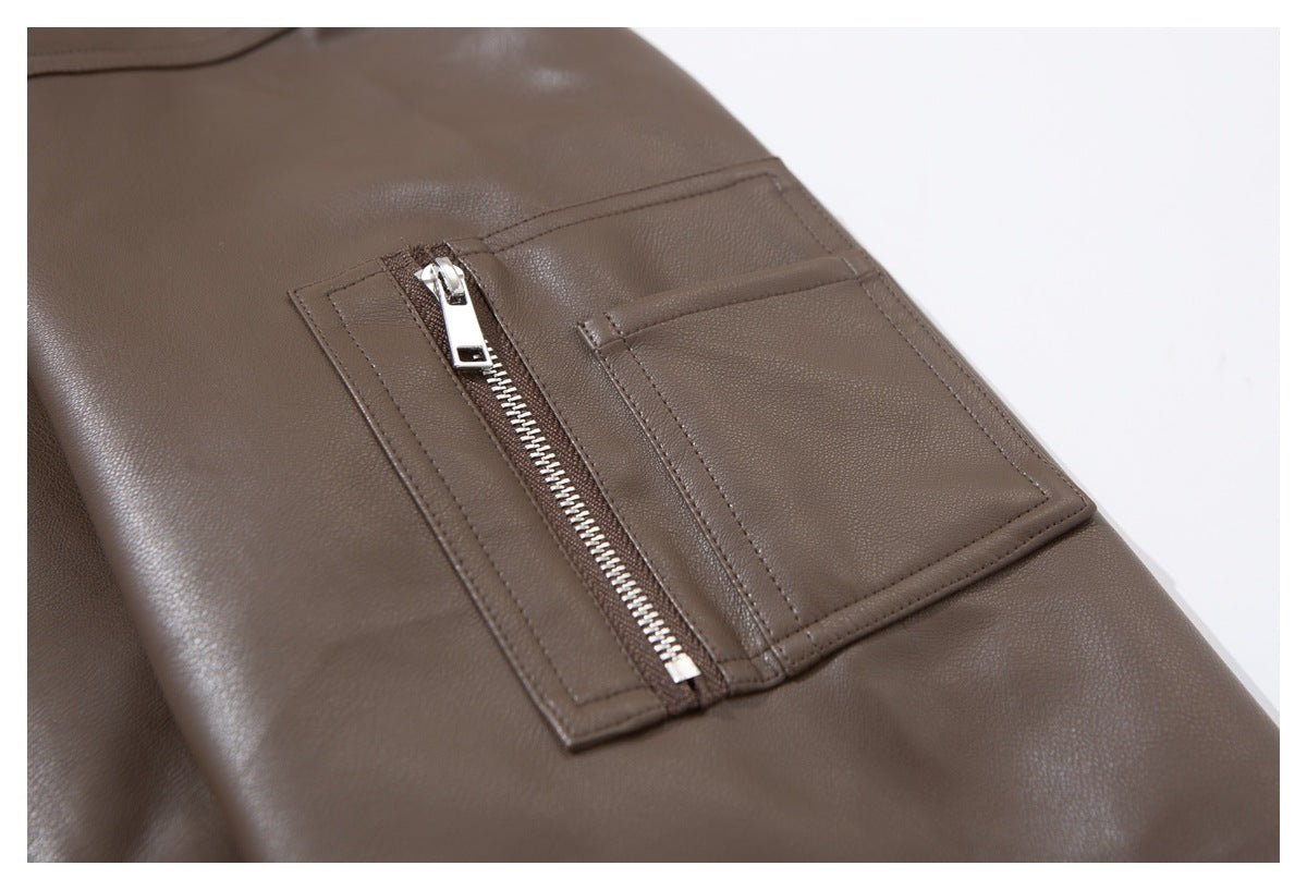 Close-up of a taupe-brown jacket showing a silver zip pocket beside a stitched rectangular pocket.