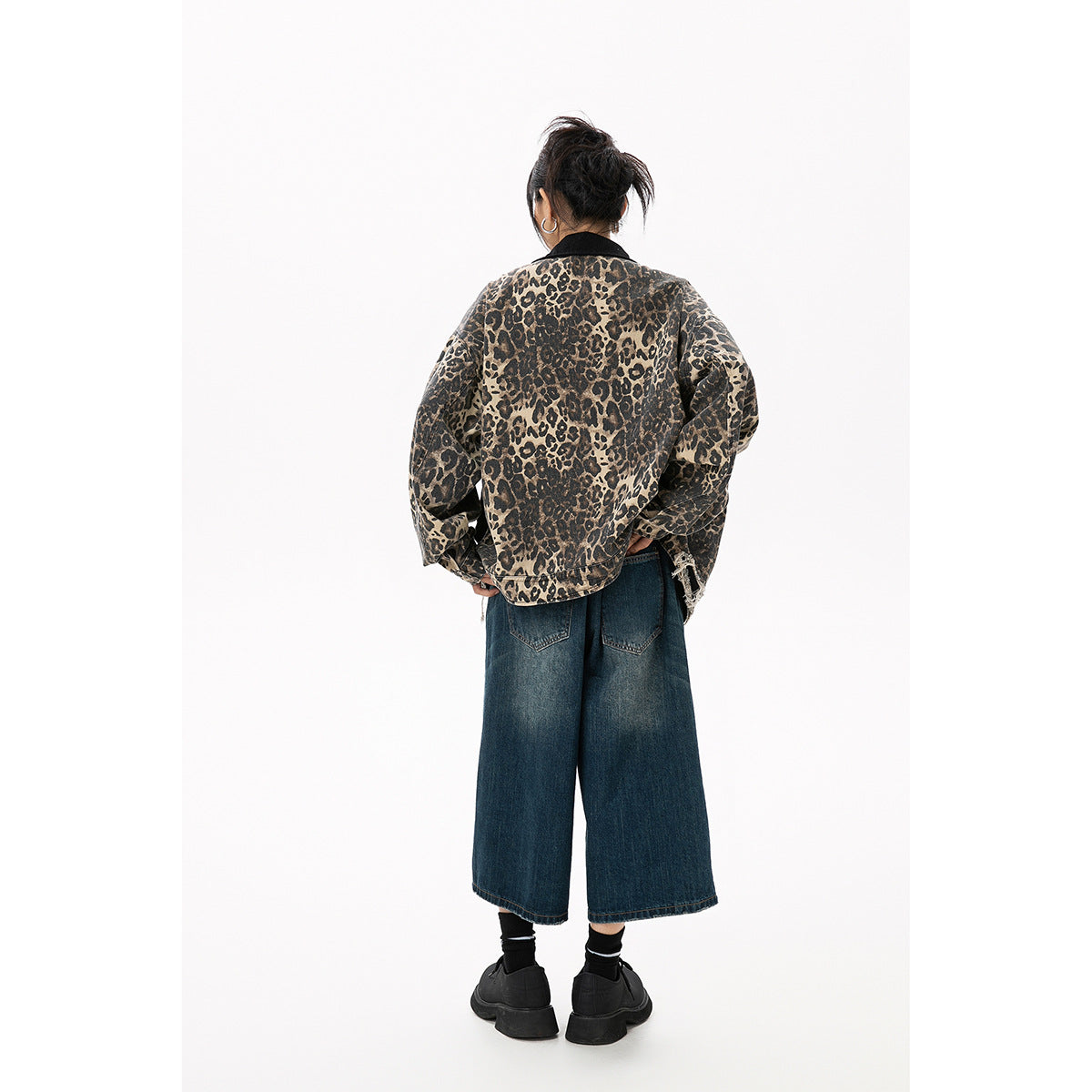 Rear view of a model wearing an oversized tan and black leopard-print jacket with a black collar and frayed hem.