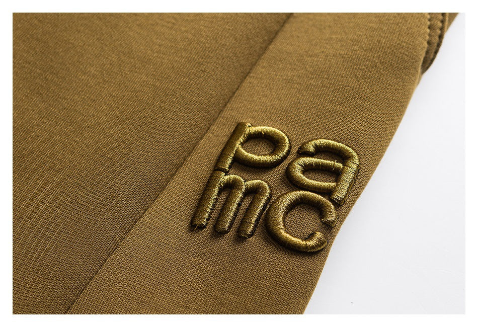 Close-up of raised ochre PAC embroidery on matching fabric.