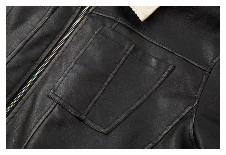 Close-up of a rectangular chest pocket and stitched paneling on a black jacket.