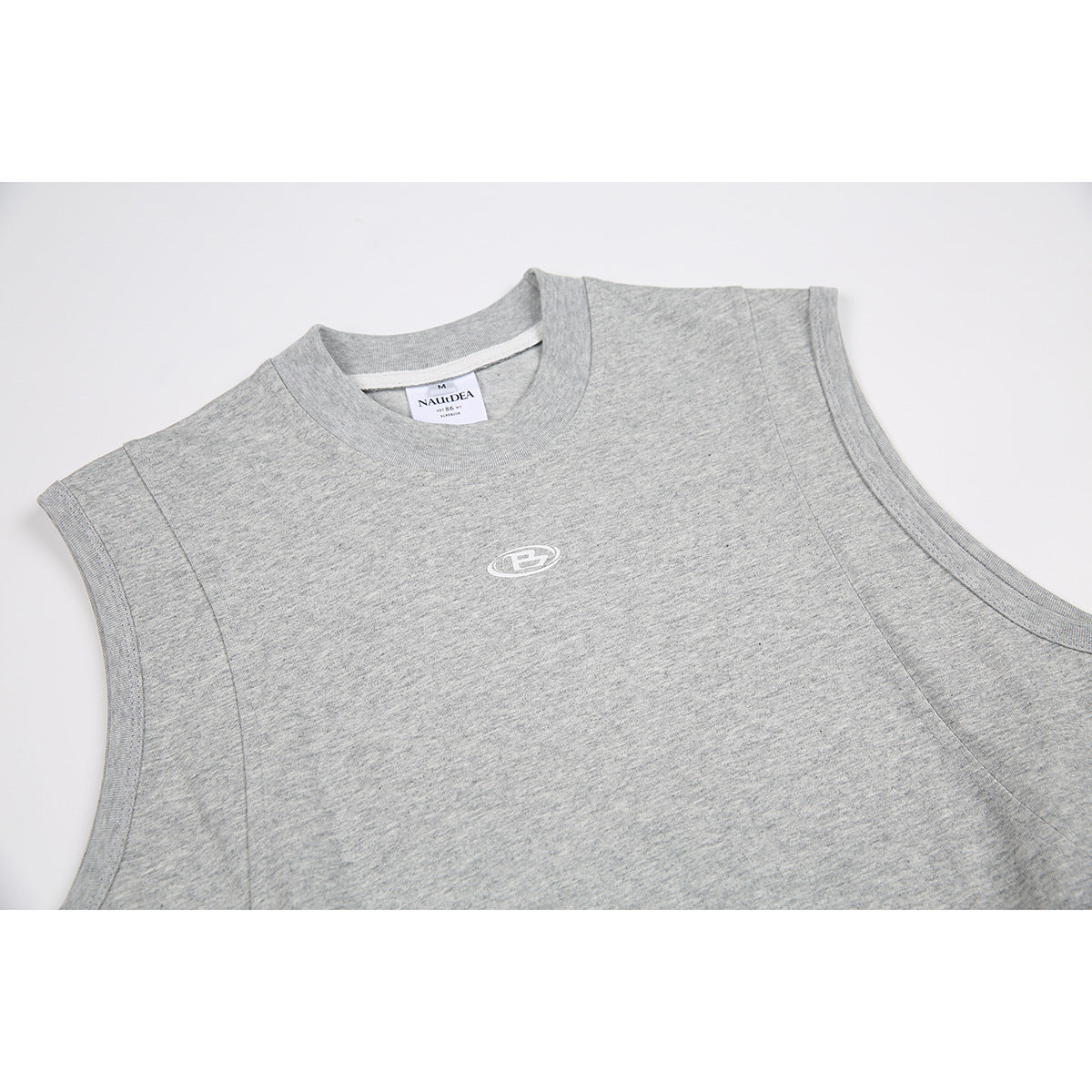 Close-up of a heather-gray sleeveless top showing its crew neck, white chest emblem, and inner neck label.