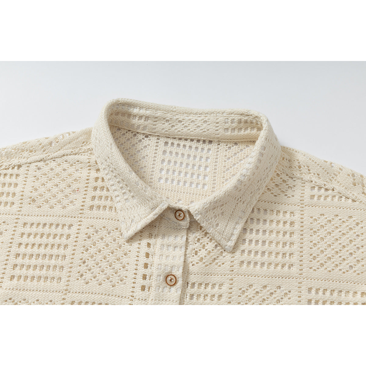 Close-up of an ivory openwork shirt collar and upper button placket.
