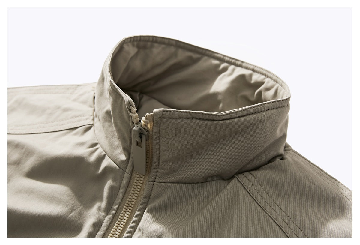 Close-up of a beige jacket's tall collar and front zipper.
