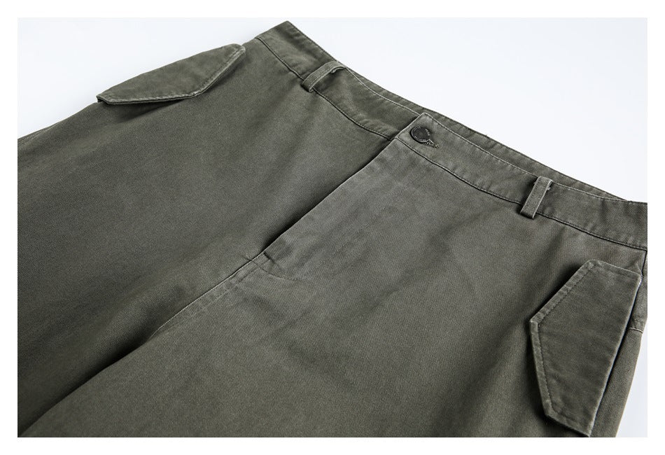 Close-up of the olive pants' waistband, button closure, belt loops, and angled side pocket.
