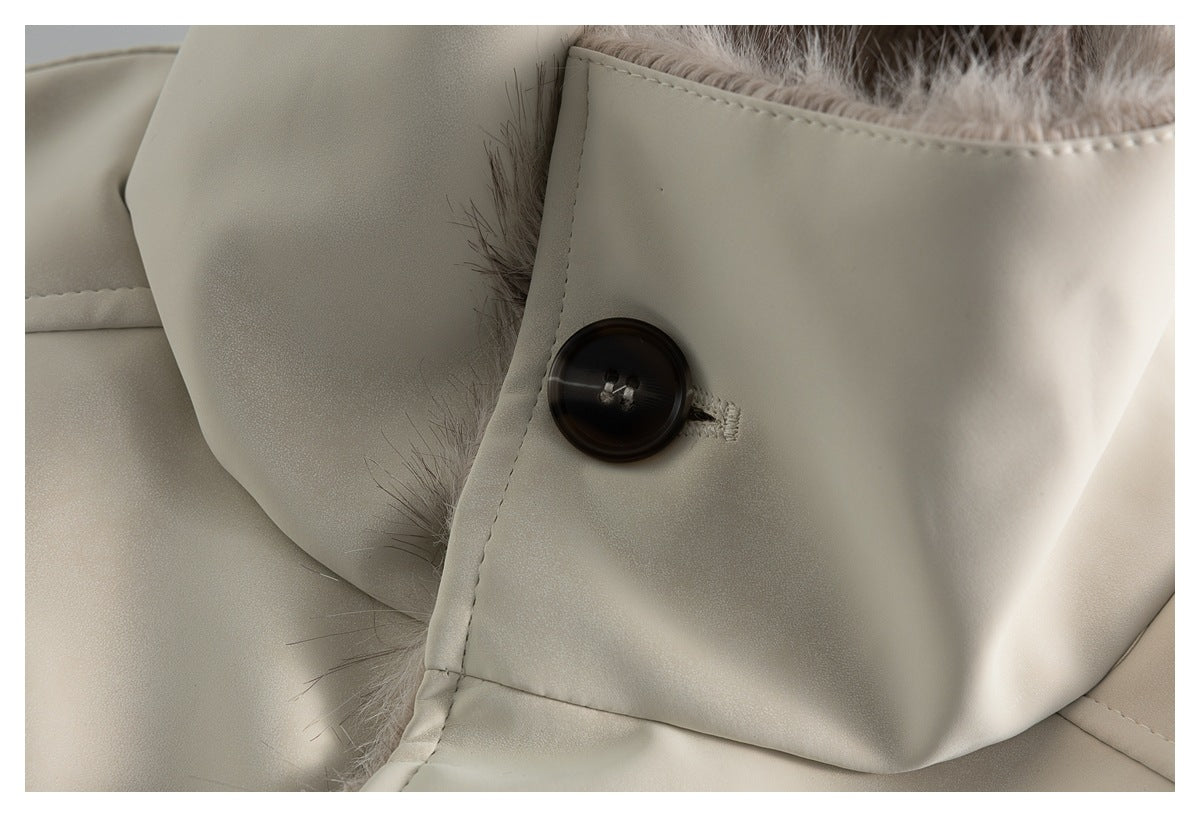 Close-up of a dark button and buttonhole on the jacket's ivory collar, with plush lining visible behind it.