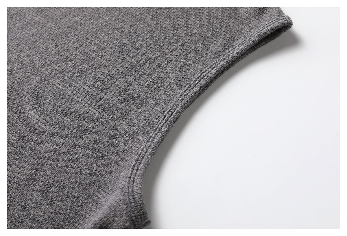 Close-up of a curved stitched edge on a gray knit garment.