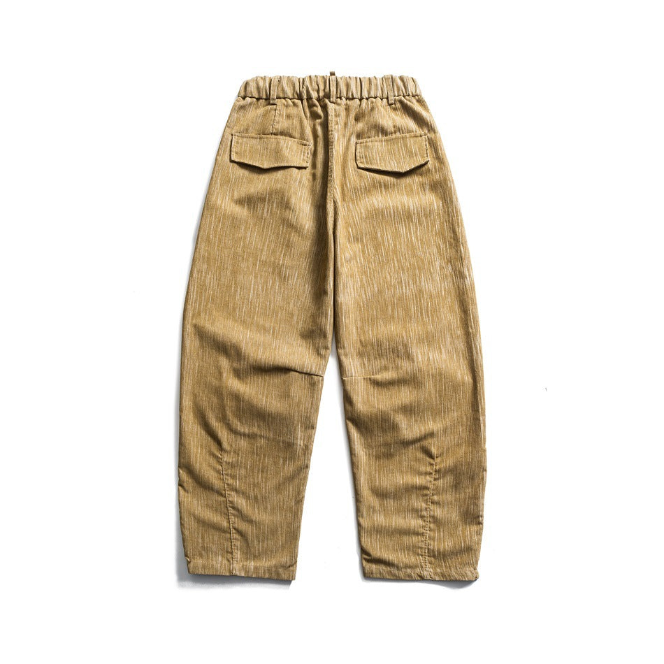 Back view of tan relaxed trousers with an elastic waist and two flap pockets.