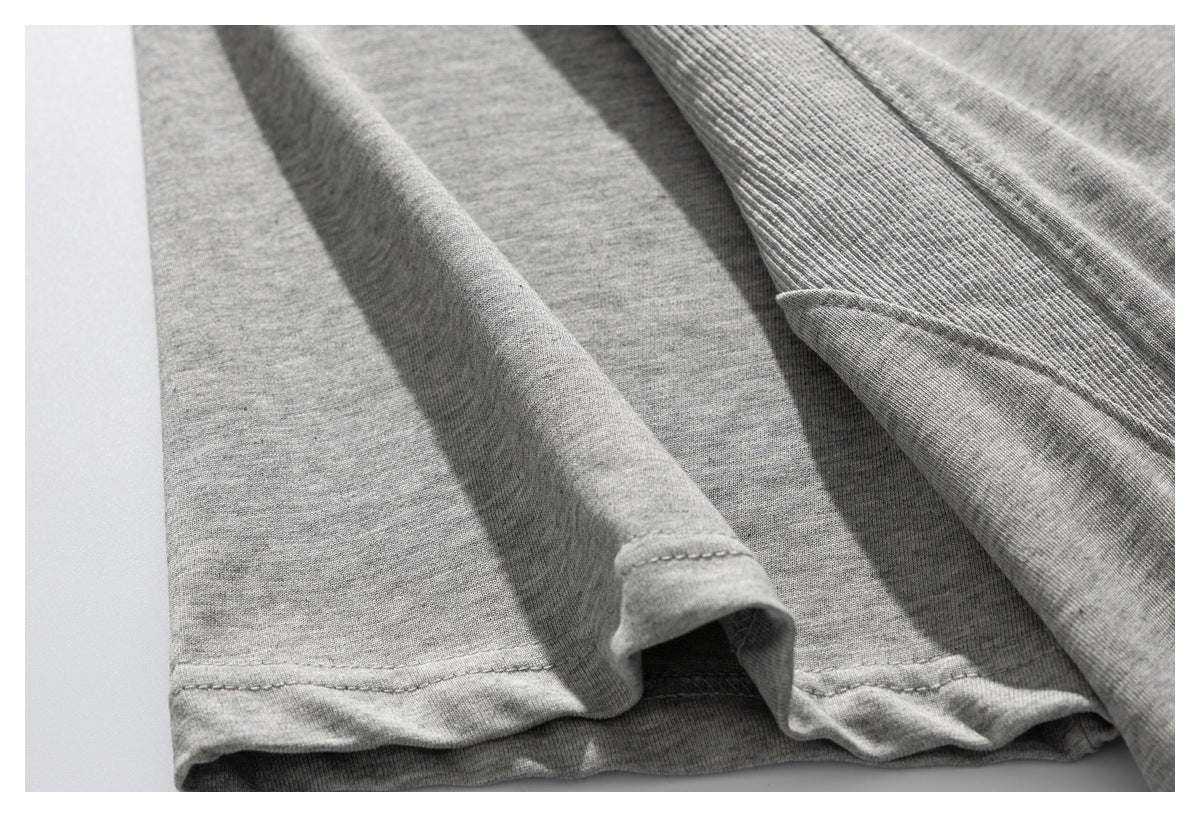 Close-up of the gray knit garment's stitched hem and folded fabric.