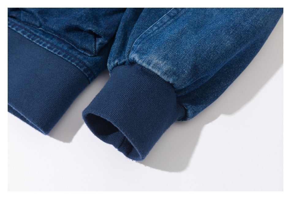 Close-up of dark blue denim jacket sleeves with ribbed cuffs.