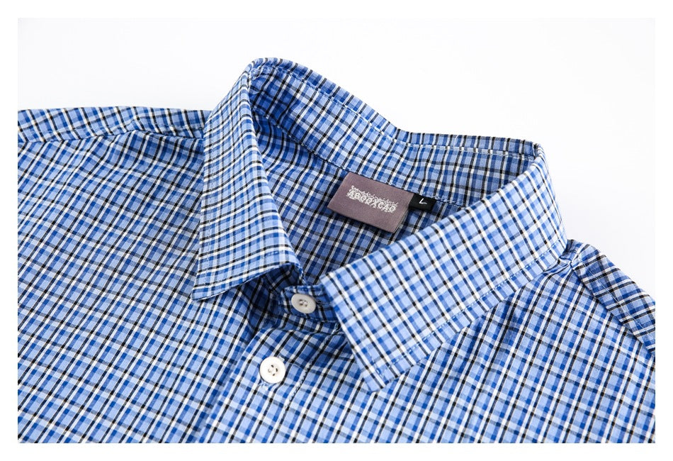 Close-up of the blue plaid shirt's pointed collar, white buttons and inside neck label.