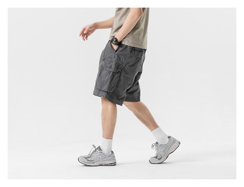 Side view of a model wearing charcoal gray cargo shorts, showing a large flap pocket.