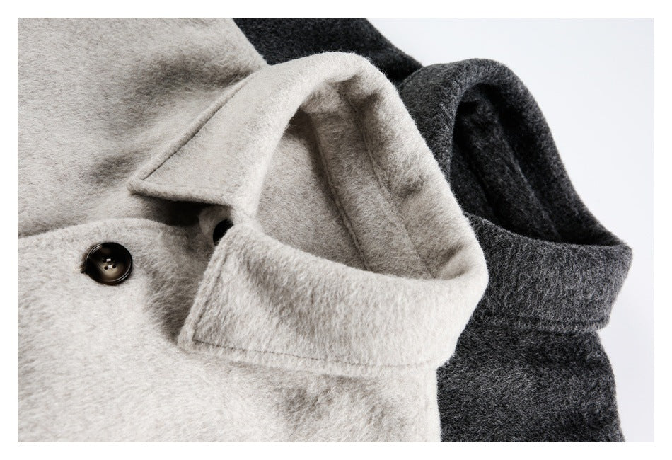 Close-up of cream and charcoal coats showing folded collars, lapels, and a dark button.