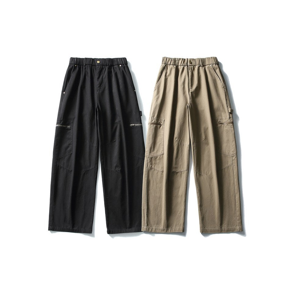 Front view of wide-leg cargo trousers in black and taupe, with elastic waists and zippered side pockets.
