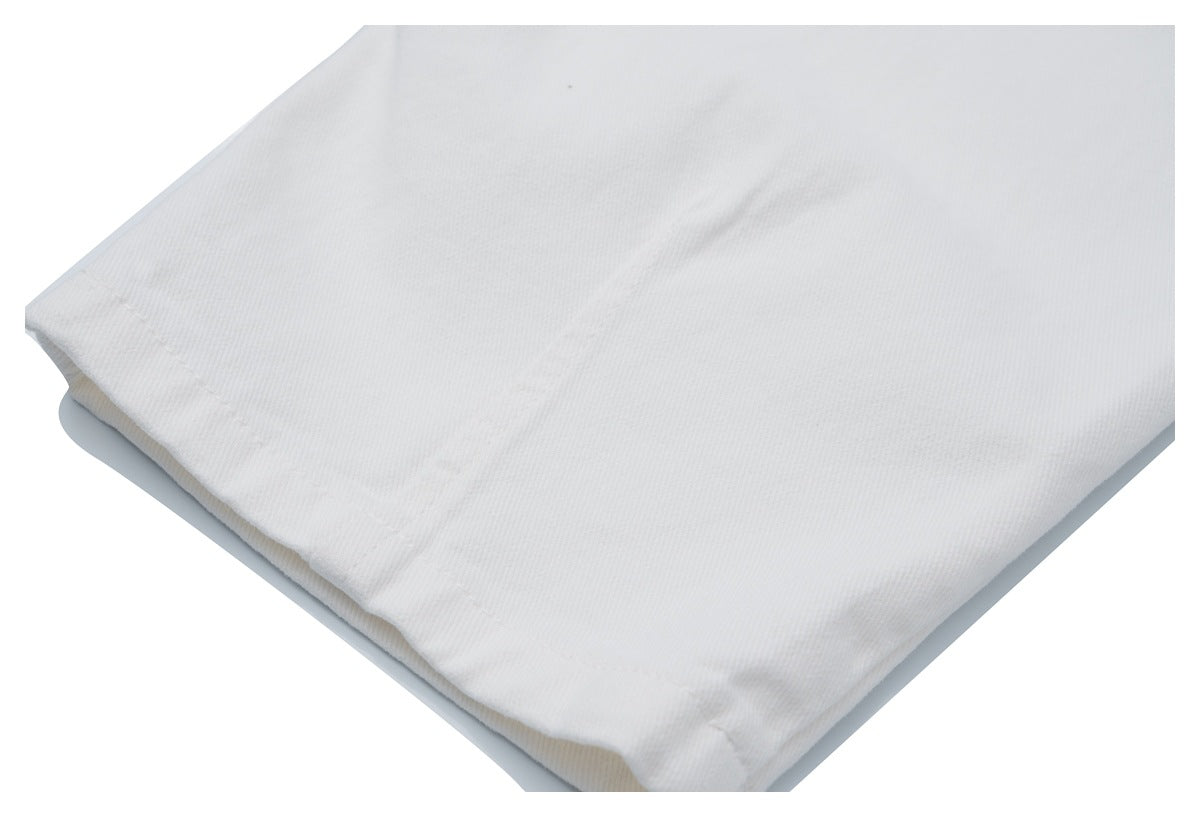 Close-up of white fabric and a folded, stitched hem.