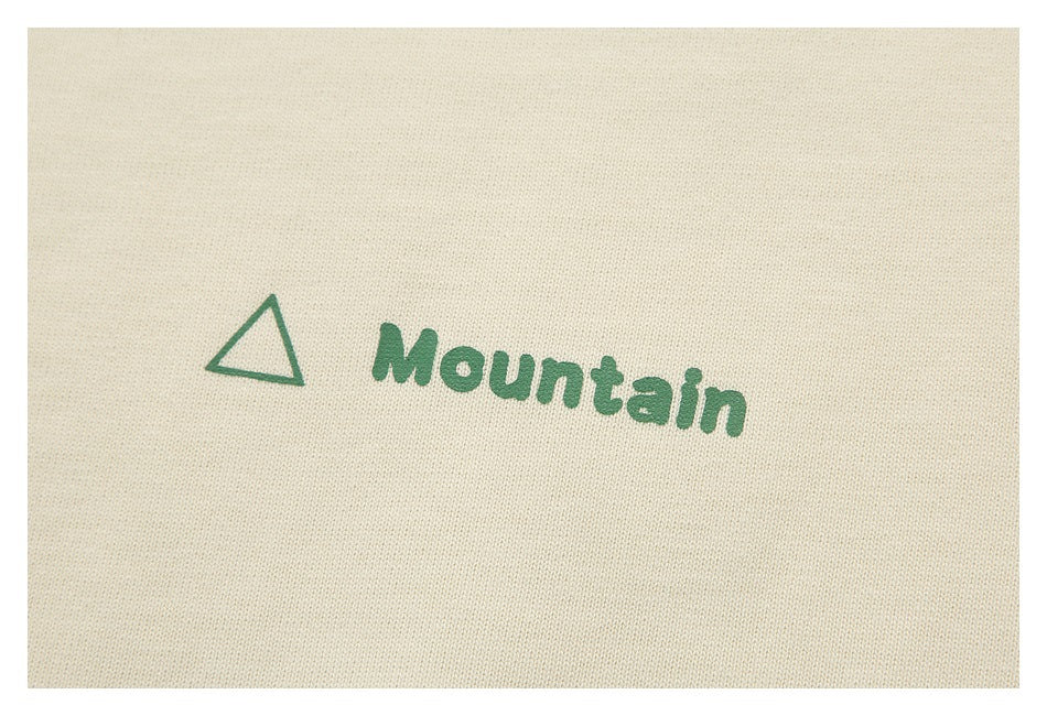 Close-up of a green triangle and Mountain print on ivory fabric.
