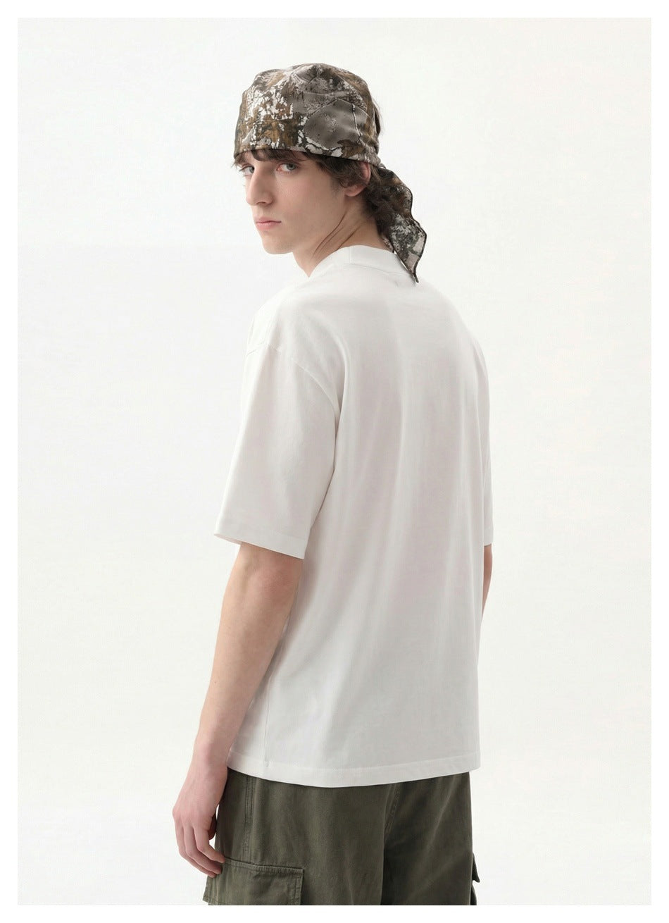 Rear view of a model wearing a plain white oversized T-shirt, olive cargo pants, and a camouflage headscarf.