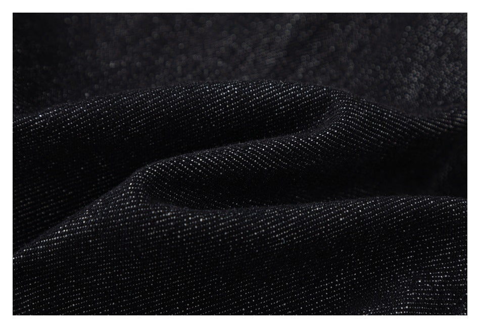 Close-up of black textured fabric with tiny light-colored flecks.