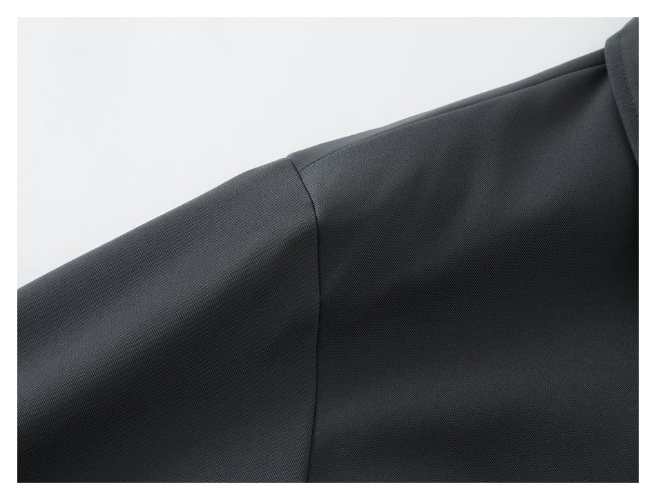 Close-up of the jacket's dark fabric and shoulder seam.