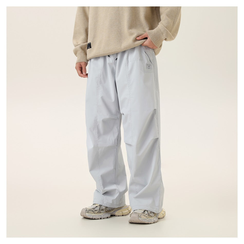 Front view of a model wearing very light gray loose pants with a side pocket and a beige sweater.