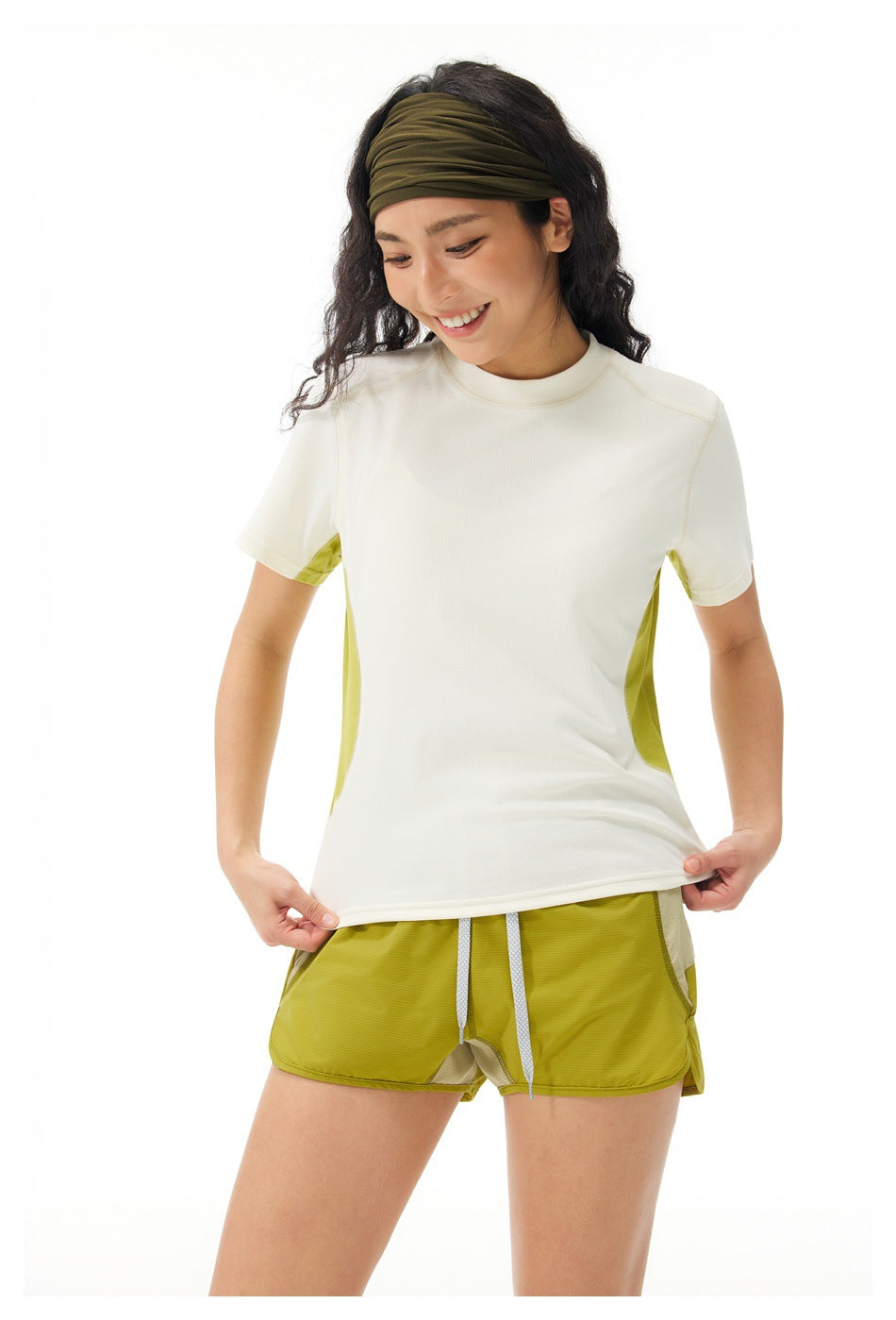 Model wearing an ivory short-sleeve athletic shirt with lime side panels and matching lime shorts.