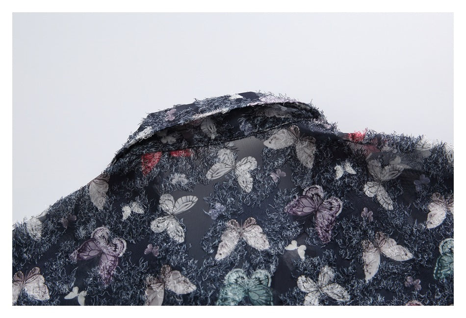 Dark navy butterfly-print fabric folded to show its textured surface and underside.