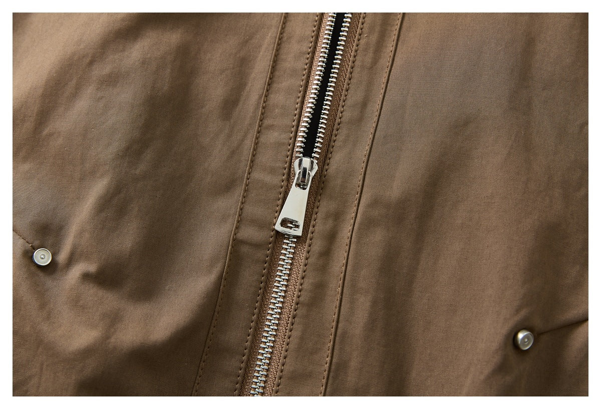 Close-up of a brown jacket's silver front zipper and snap buttons.