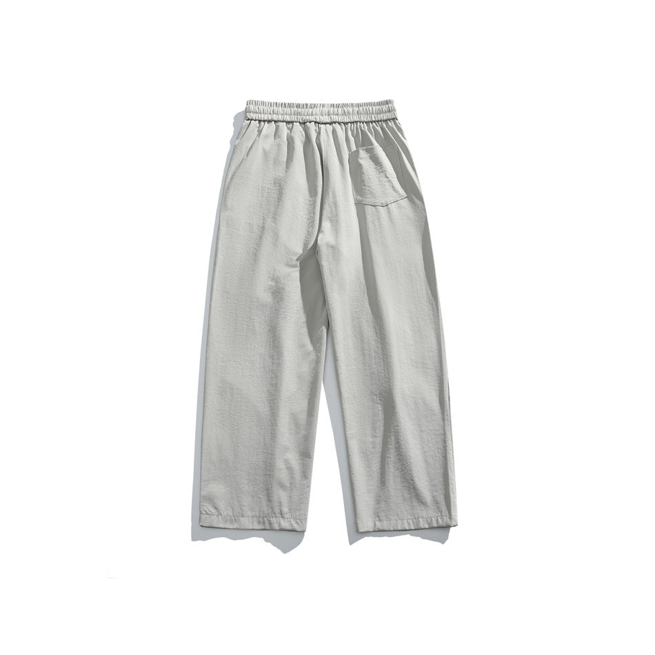 Back view of light gray wide-leg pants with an elastic waist and a single patch pocket.
