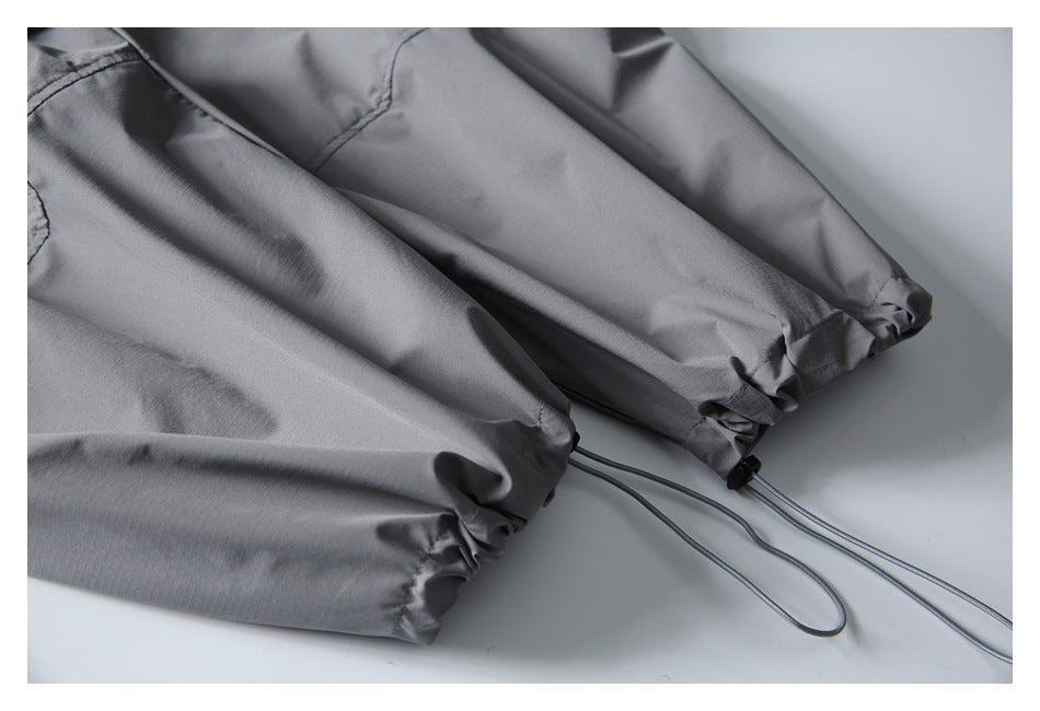 Close-up of gray pant legs with gathered hems and adjustable drawcords.