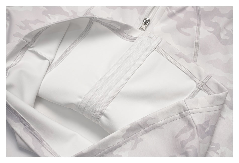 Close-up of a zipper and stitched interior panels on a pale gray camouflage garment.