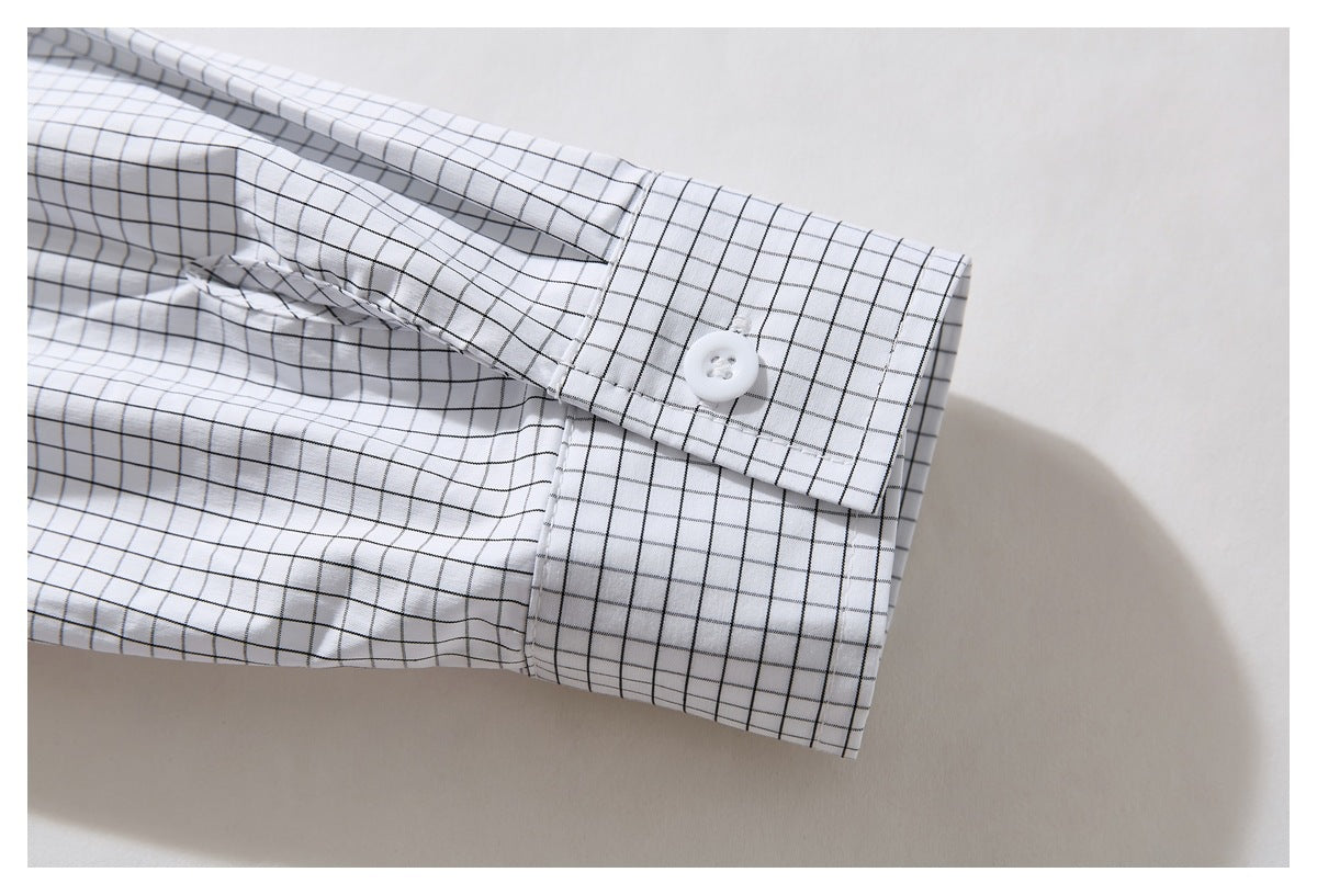 Close-up of the white shirt's black grid-patterned sleeve cuff and button.