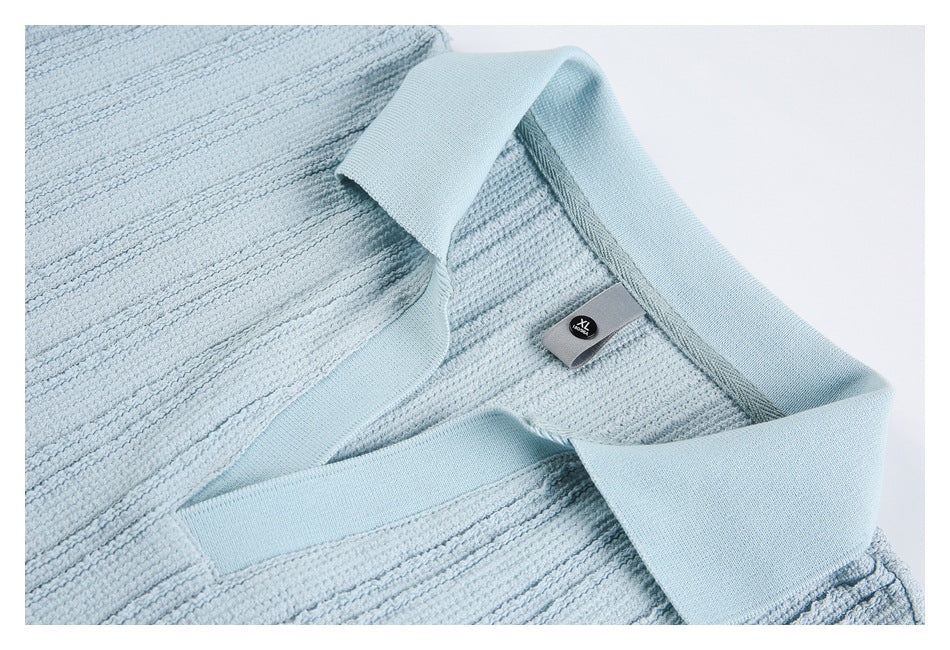 Close-up of a pale blue textured polo shirt collar and neckline with an XL size tag.