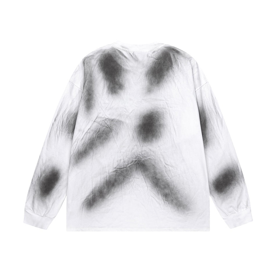 Back view of a white long-sleeve crewneck shirt with irregular charcoal-gray tie-dye patches.