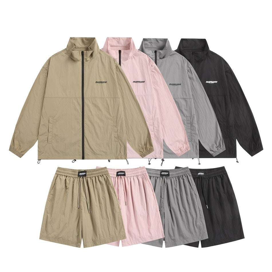 Four colorways of a zip-front jacket and matching shorts in beige, pink, gray, and black, shown from the front.