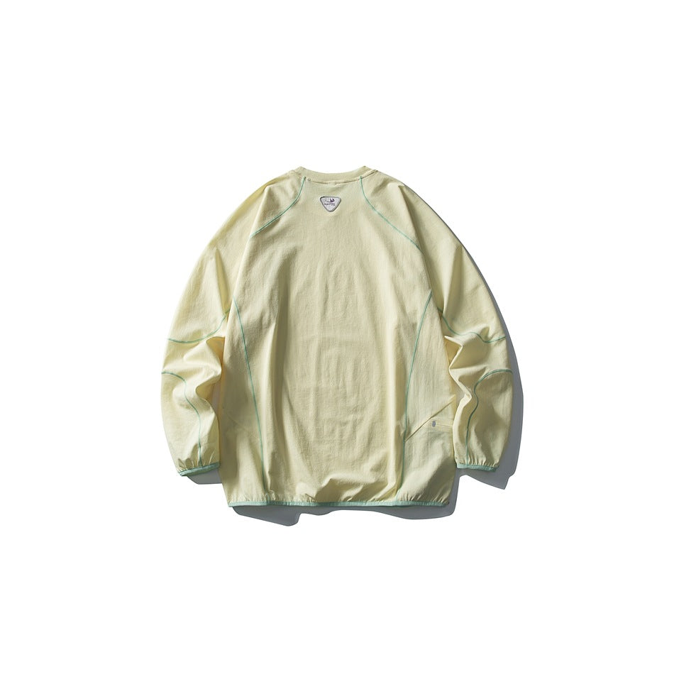 Pale yellow long-sleeve crewneck pullover shown from the back, with green seam piping and a small neck emblem.