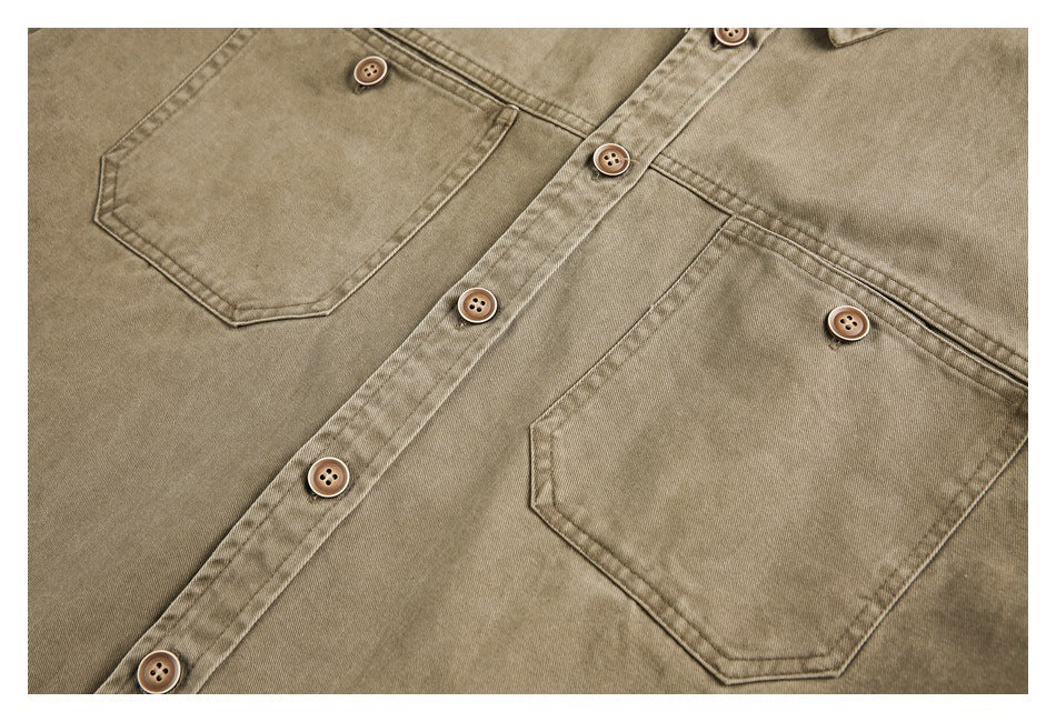 Close-up of a tan button-up shirt front with two chest pockets and a row of brown buttons.